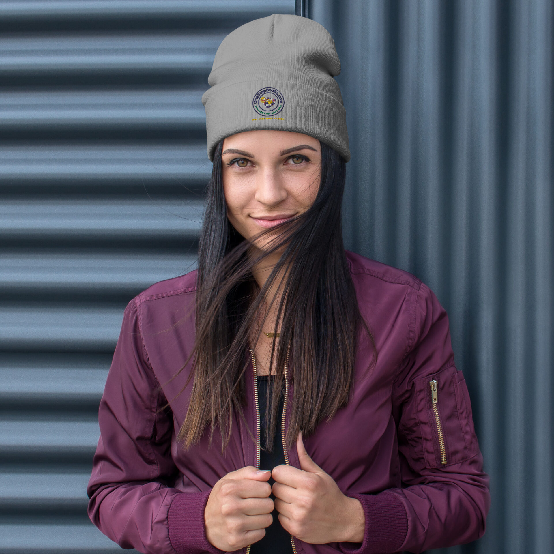 Woman wearing a grey beanie with a logo.