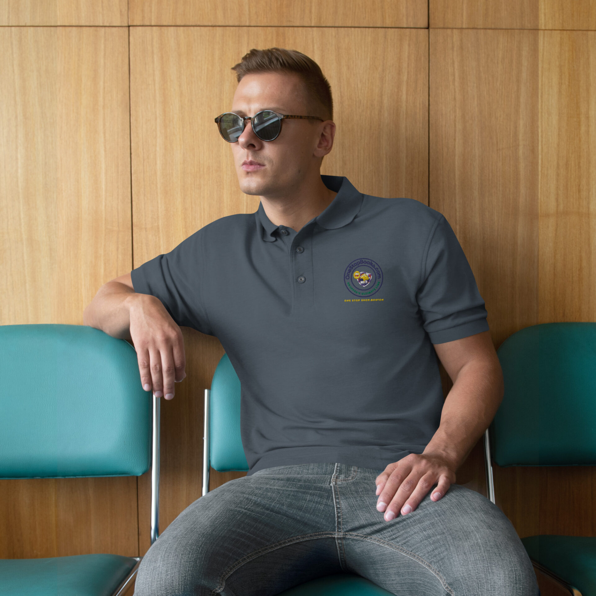 Man wearing a grey polo shirt with a logo.