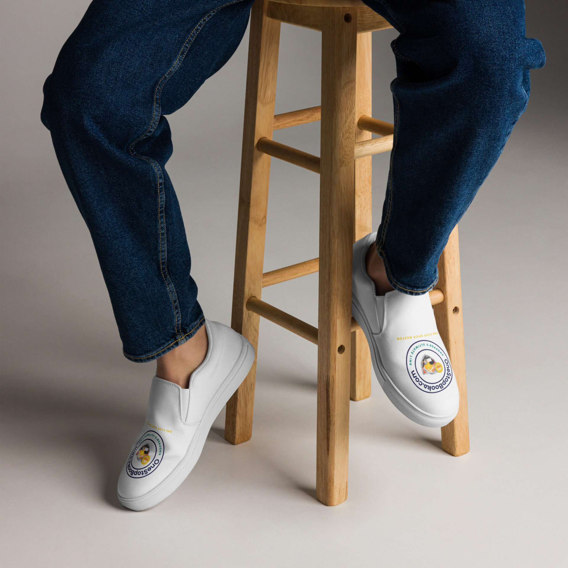 Person wearing white slip-on shoes with logo.