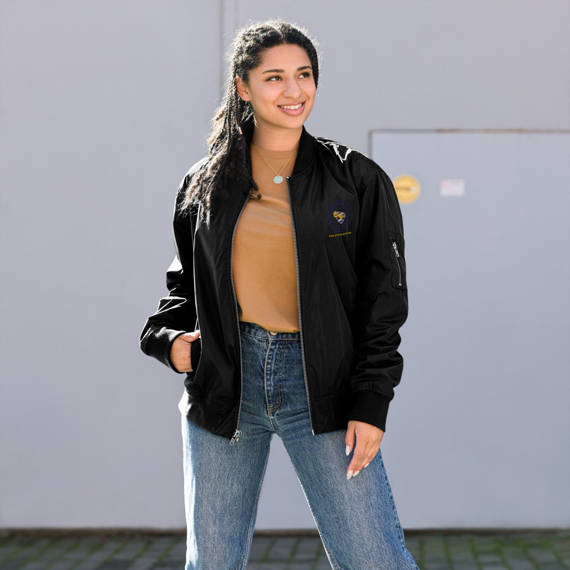 Woman in black bomber jacket and jeans.